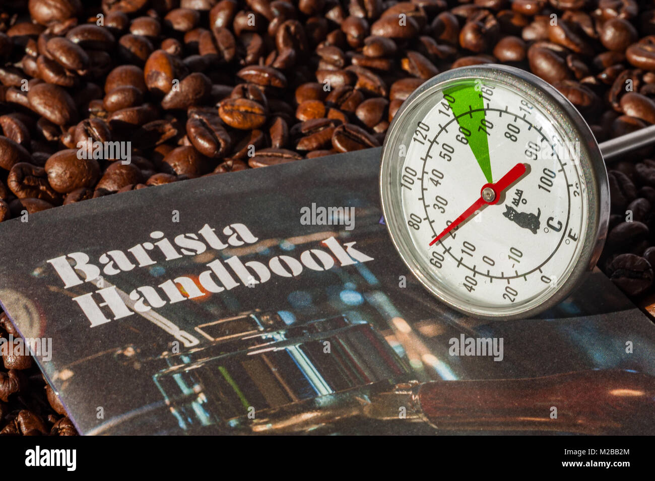 Barista Handbuch und Milch Thermometer auf einem Hintergrund von gerösteten Kaffeebohnen mit kopieren. Stockfoto