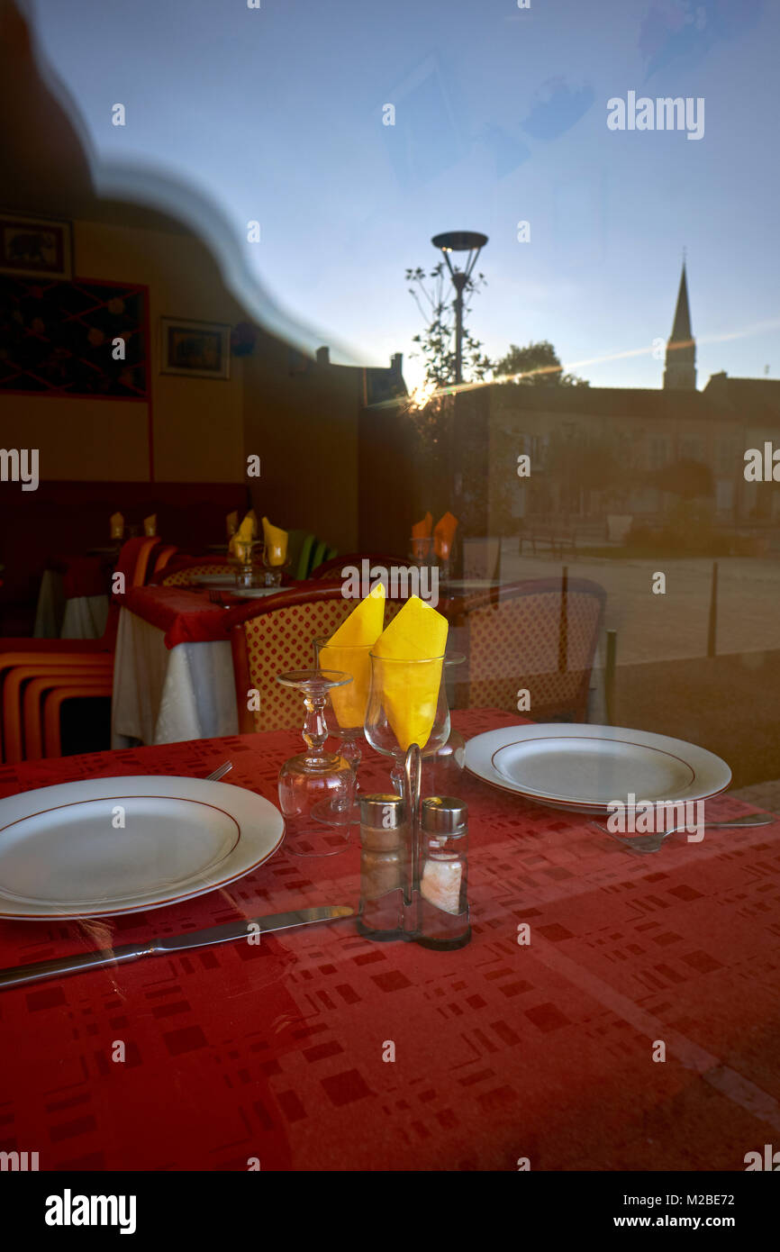 Tisch für zwei - Gelbe Servietten und ein roter Tisch Tuch eines Restaurantfensters Stockfoto
