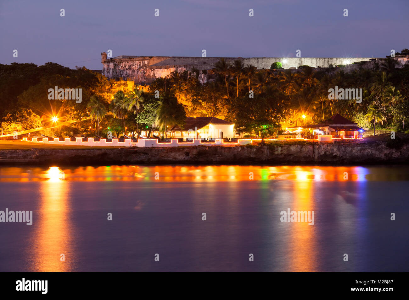 Restaurants und Fortaleza de San Carlos de La Cabaña bei Nacht beleuchtet auf Bucht von Havanna in Casablanca, Havanna, Kuba. Stockfoto