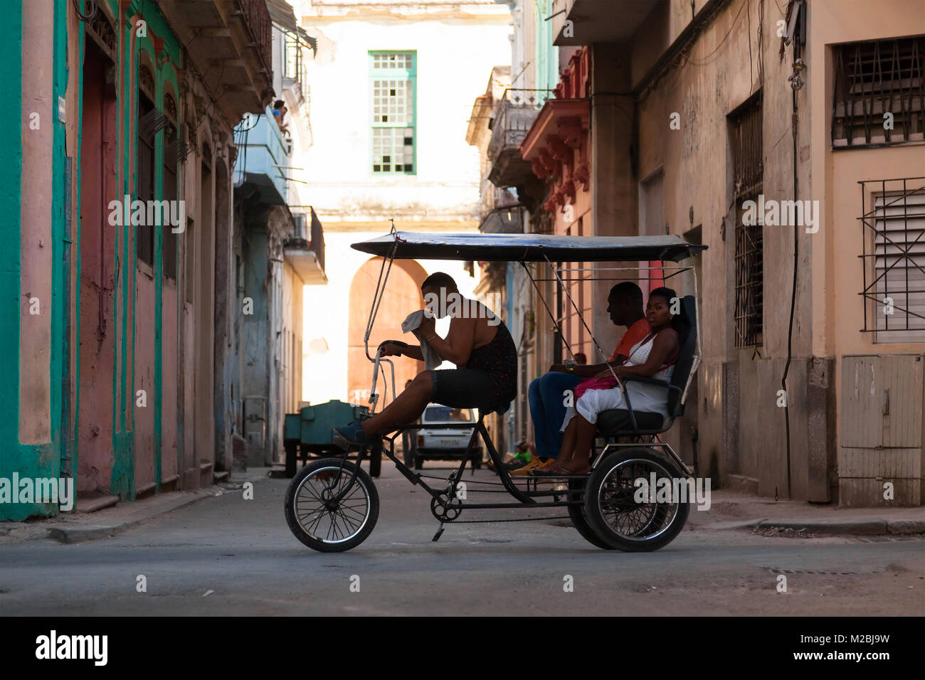 Ein Zyklus Rikscha mit Passagieren auf der Straße in Havanna, Kuba. Stockfoto