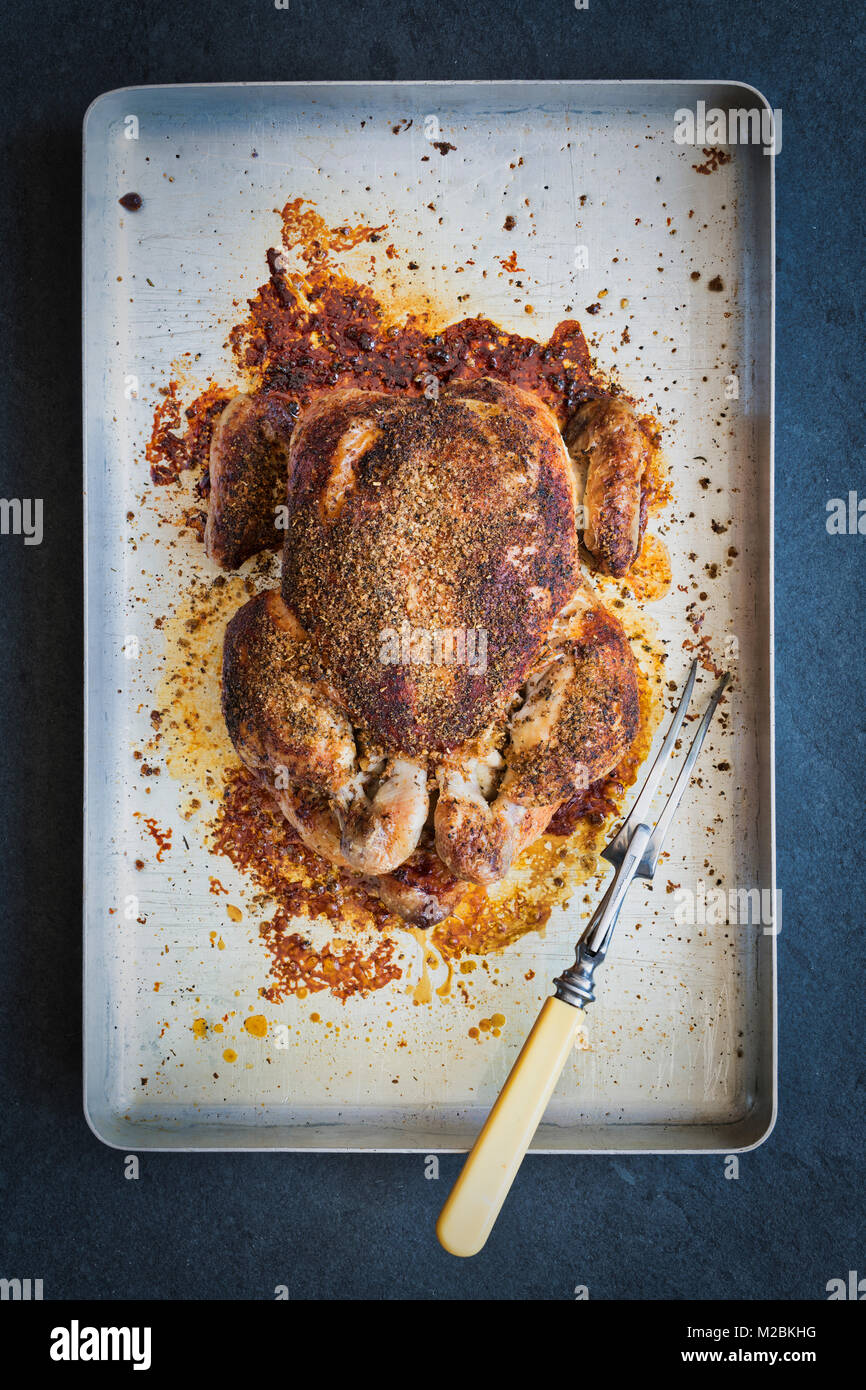 Gebratenes Huhn mit einem pflanzlichen Crumb auf einem bratplatte auf einer Schiefertafel Hintergrund. Großbritannien Stockfoto