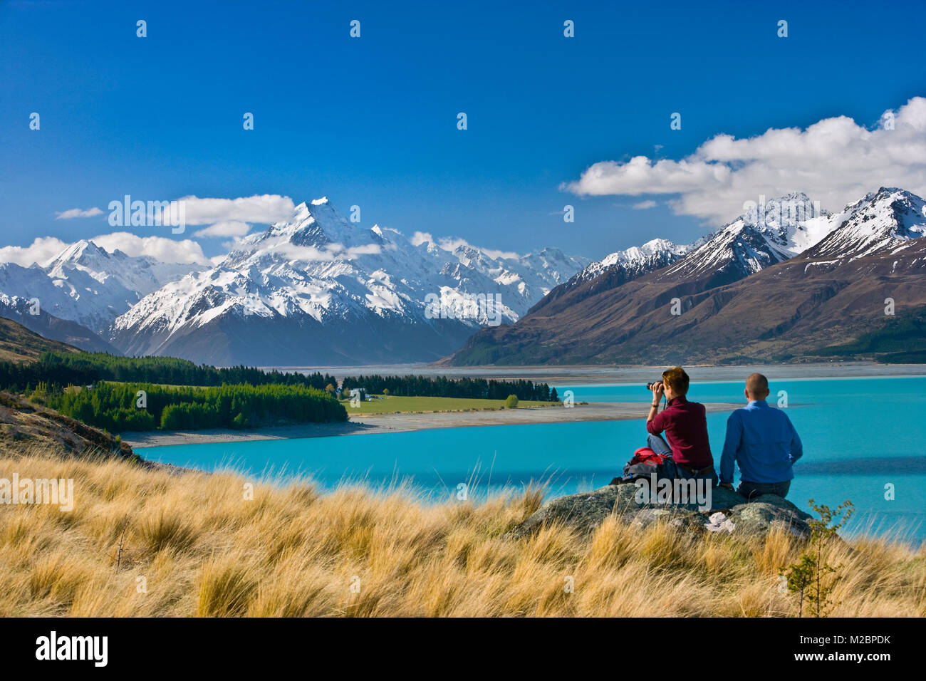 Neuseeland, Südinsel, Lake Pukaki und im Hintergrund Mount Cook Nationalpark. Paar wandern. Blick durch ein Fernglas. Unesco Welterbe s Stockfoto