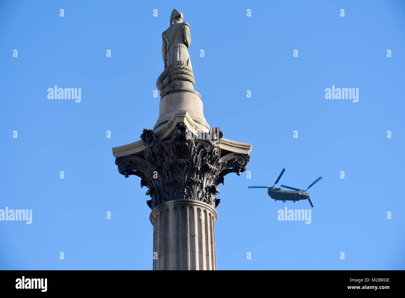 Boeing Chinook Hubschrauber der Royal Air Force fliegt über London vorbei an Admiral Nelson auf der Nelson's Column am Trafalgar Square Stockfoto