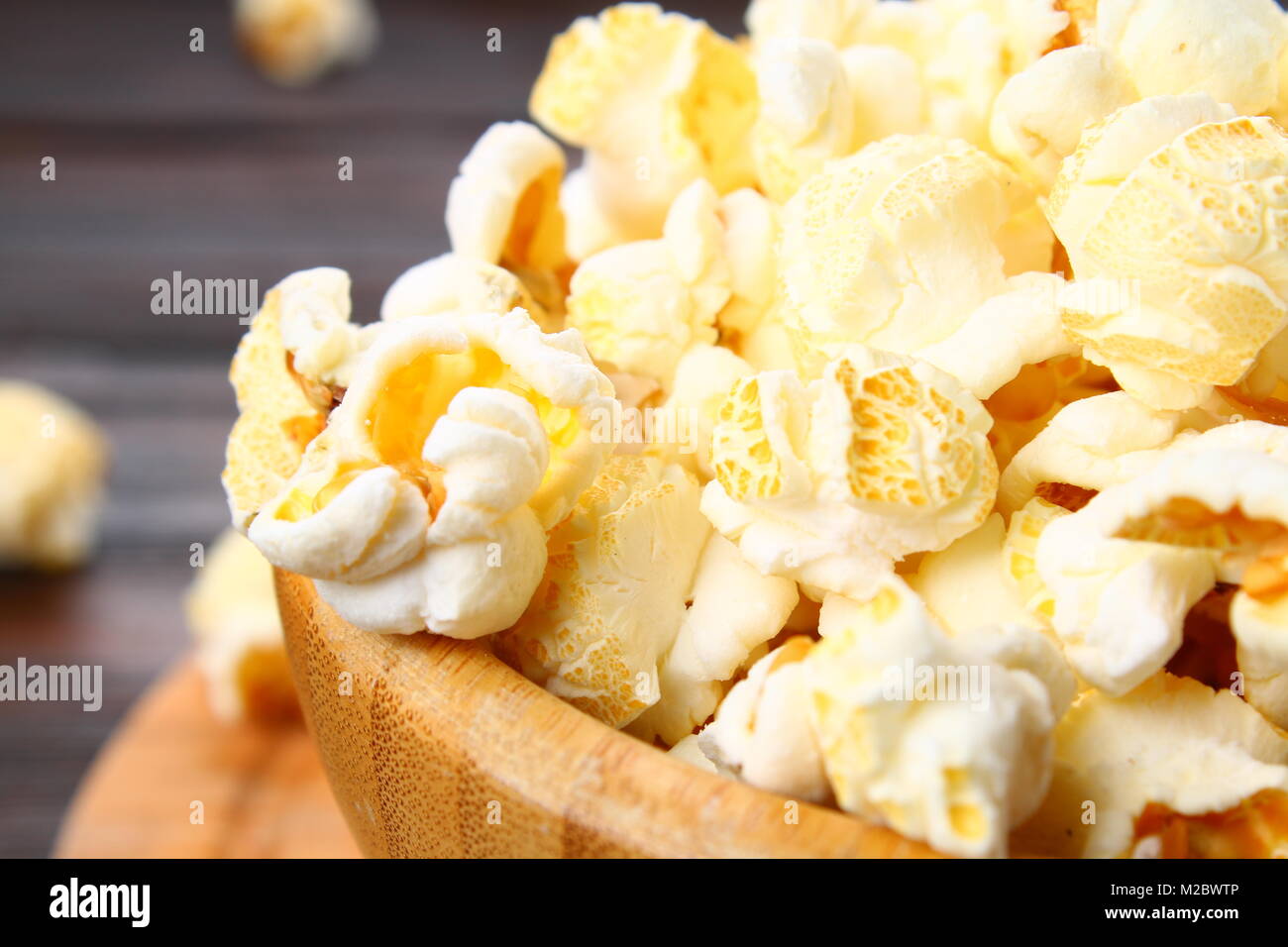 Gesalzene Popcorn in eine hölzerne Schüssel auf einen hölzernen Tisch Stockfoto