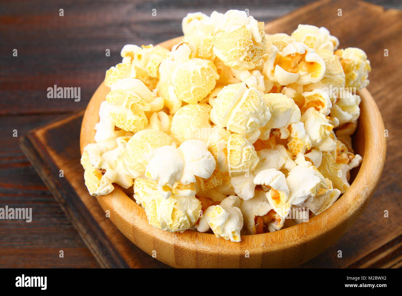 Gesalzene Popcorn in eine hölzerne Schüssel auf einen hölzernen Tisch Stockfoto