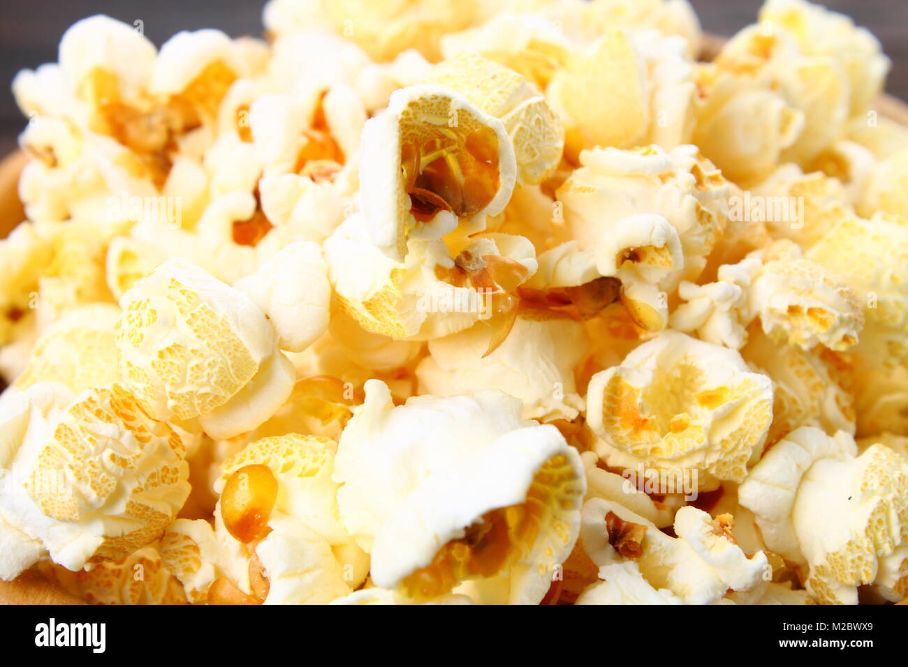 Samen von gesalzenem Popcorn auf einem Holztisch Stockfoto