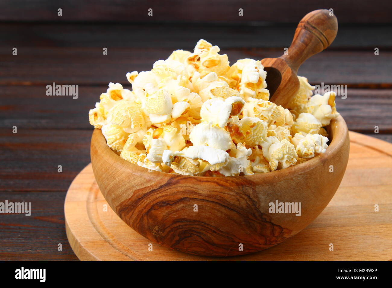 Gesalzene Popcorn in eine hölzerne Schüssel auf einen hölzernen Tisch Stockfoto