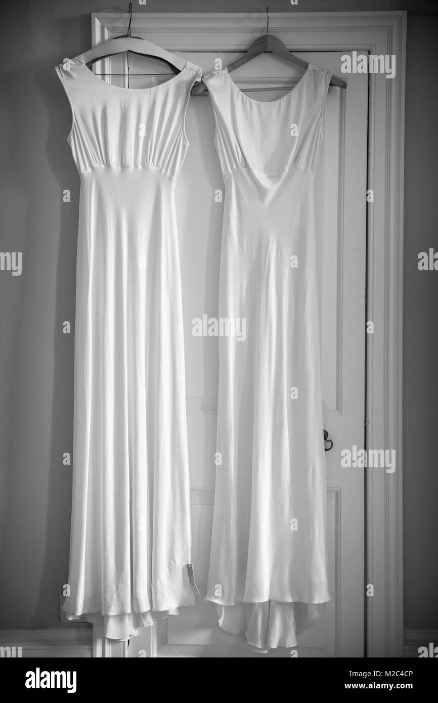 Zwei Hochzeit Kleider hängen am Türrahmen Stockfoto