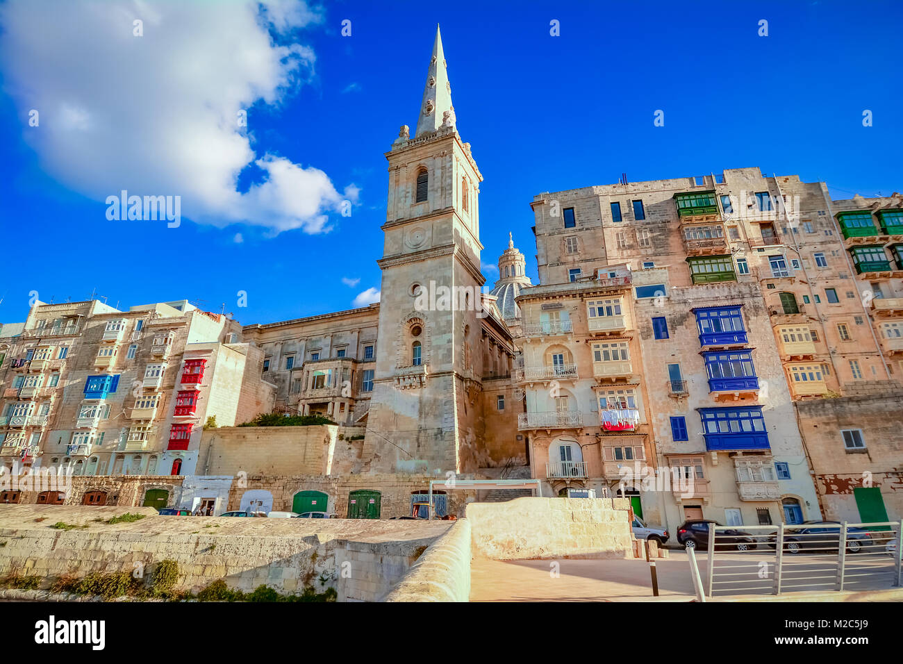 Valletta, Malta - St. Paul's Anglican Turm der Kathedrale zwischen den Häusern, vom Hafen gesehen. Stockfoto