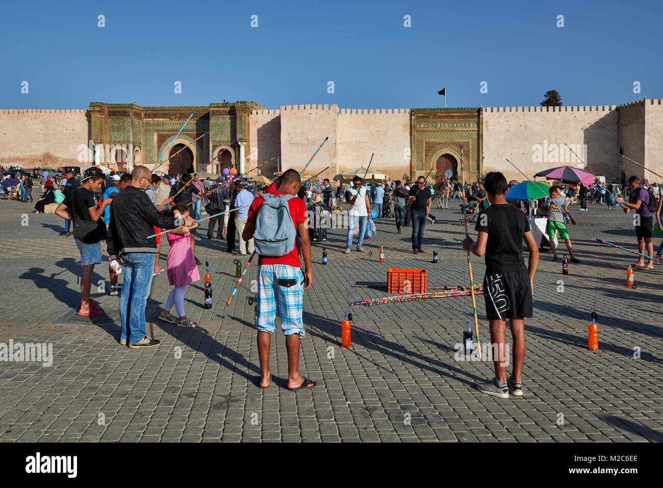 Menschen auf Lahdim Platz mit Bab Mansour City Gate hinter, Meknes, Marokko, Afrika Stockfoto