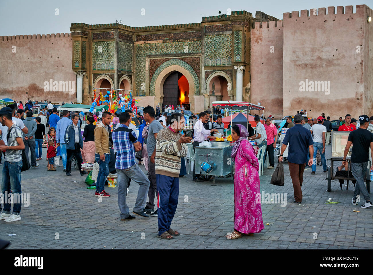 Menschen auf Lahdim Platz mit Bab Mansour City Gate hinter, Meknes, Marokko, Afrika Stockfoto