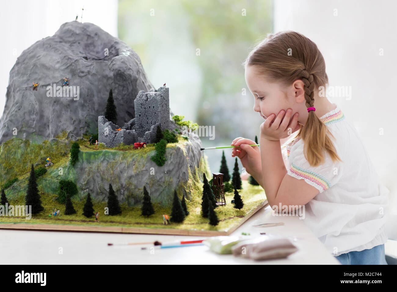 Kinder arbeiten an Modellbau Schulprojekt. Kinder bauen Miniatur Maßstab Modell Mountain für Erdkundeunterricht. Außerschulische Aktivitäten und Hobby-cl Stockfoto