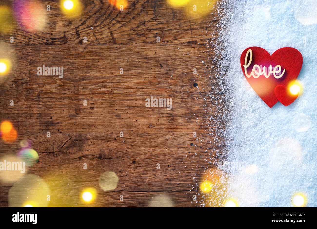 Filz rote Herzen und Holz- Inschrift 'Liebe' auf Schnee und im Hintergrund. Liebe und St. Valentines Tag Konzept. Stockfoto