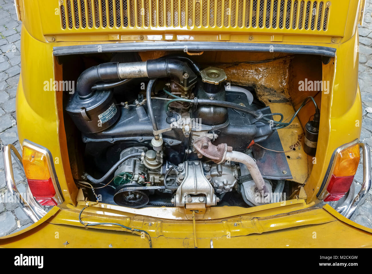 Auto Motorhaube öffnen. Motor, Getriebe, Fiat 500 1970 hergestellt. Alter Stil, Klassik, Vintage, retro Auto. Farbe gelb. Nahaufnahme, oben betrachten. Stockfoto