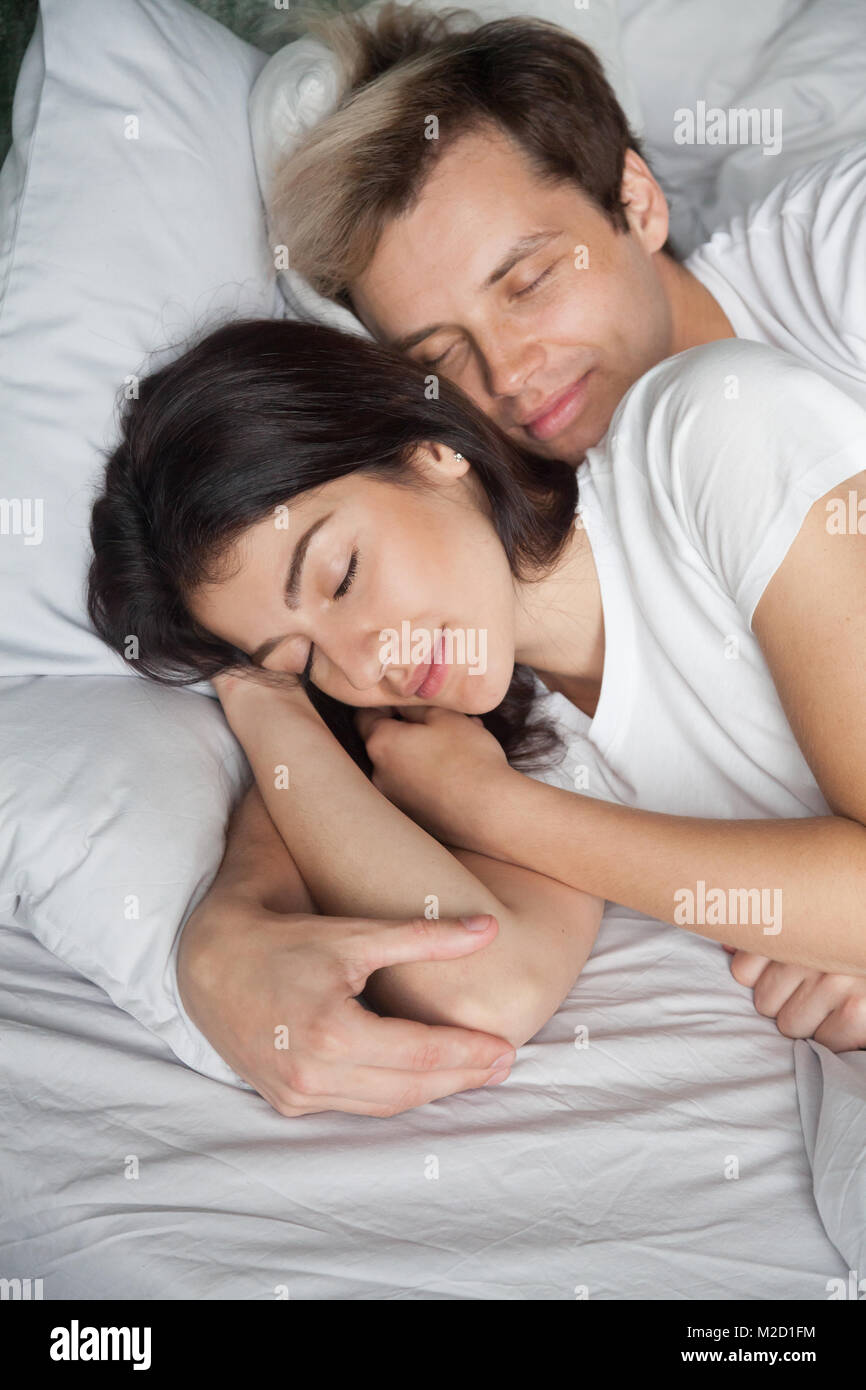 Schöne junge Paare schlafen im Bett zu Hause zusammen, vertica Stockfoto