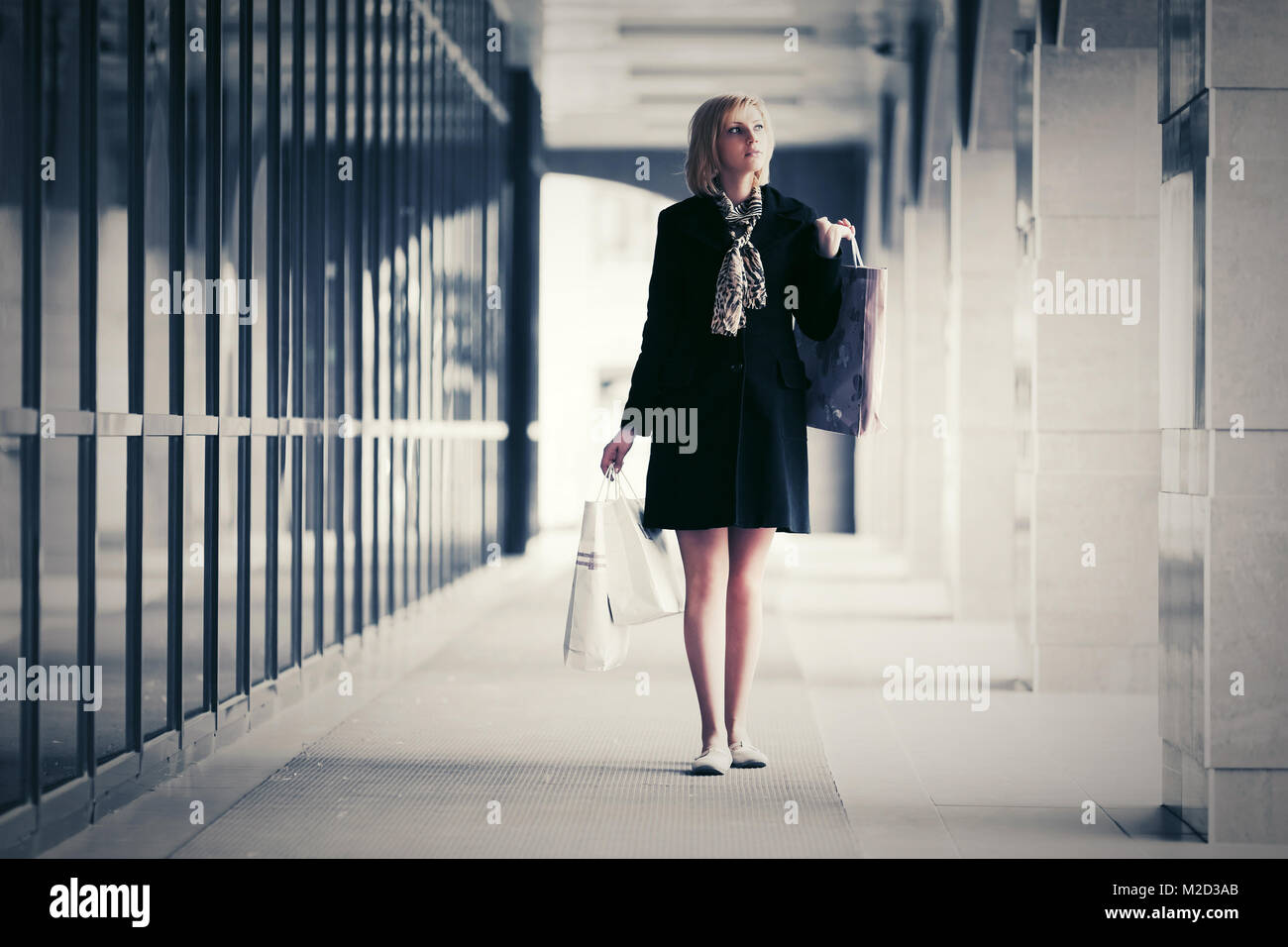 Junge Mode Frau mit Einkaufstüten zu Fuß in die mall Stockfoto