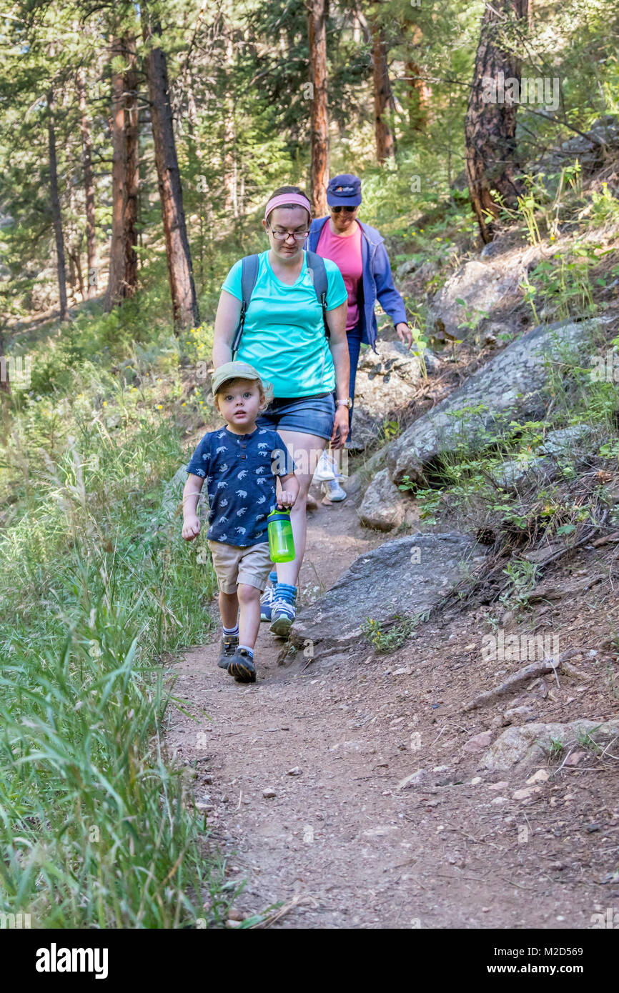 Kittredge, Colorado - Adam Hjermstad jr., 3, trägt eine Flasche Wasser, wie er seiner Mutter und Großmutter auf eine Wanderung auf dem Panorama Point Trail führt. Stockfoto