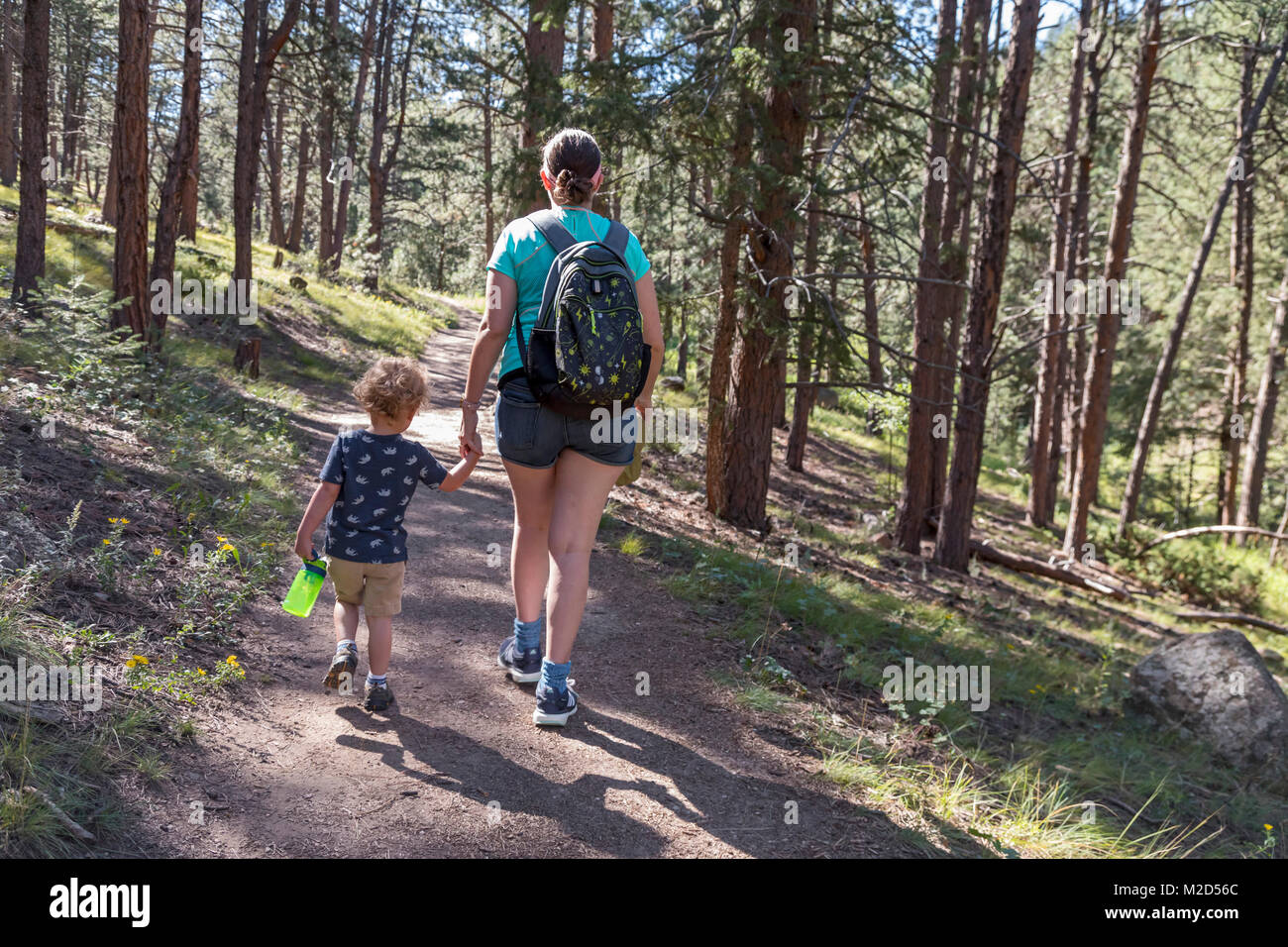 Kittredge, Colorado - ein 3-jähriger Junge trägt eine Wasserflasche wie Wanderungen mit seiner Mutter auf dem Panorama Point Trail. Stockfoto