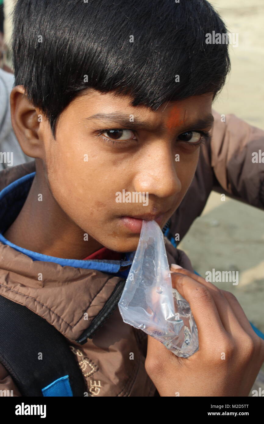 Porträt einer Indischen jugendlich Pilgrim junge Trinkwasser durch das Saugen wasser Tasche Stockfoto