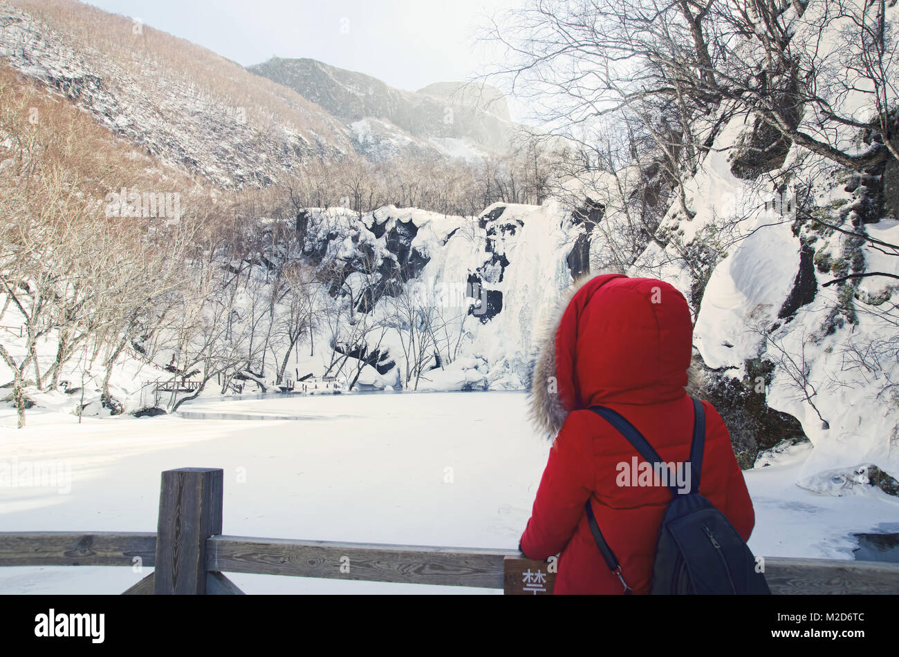 Ein Tourist genießen Sie den Blick von gefrorenen Grünen tiefen Pool in Changbai Mountain Scenic Area Stockfoto