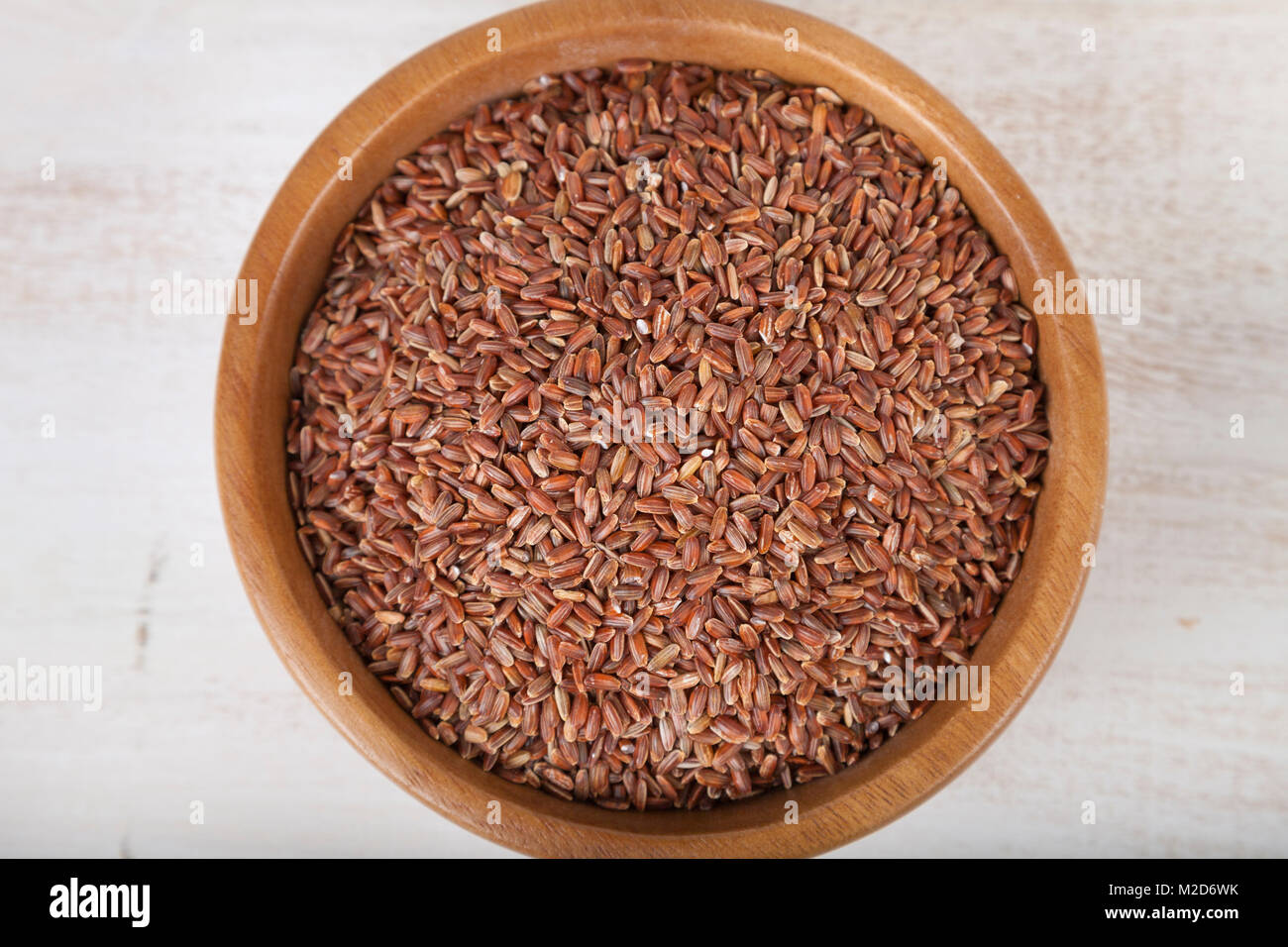 Roher Roter Reis in eine Schüssel geben und mit einem Holzlöffel  Stockfotografie - Alamy
