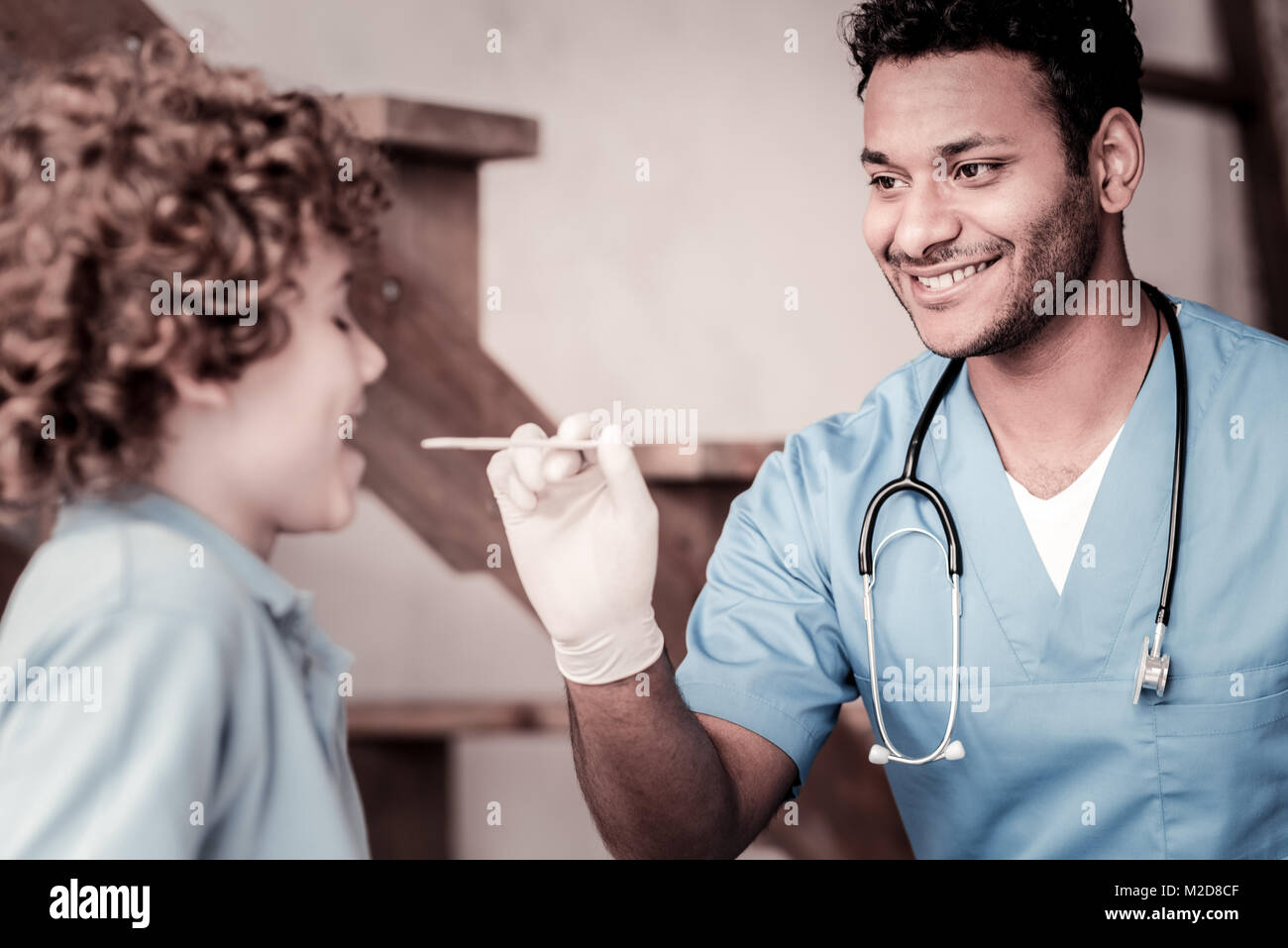 Positiv gesinnten medizinischer Arbeiter Kontrolle Kehle von Kind Stockfoto