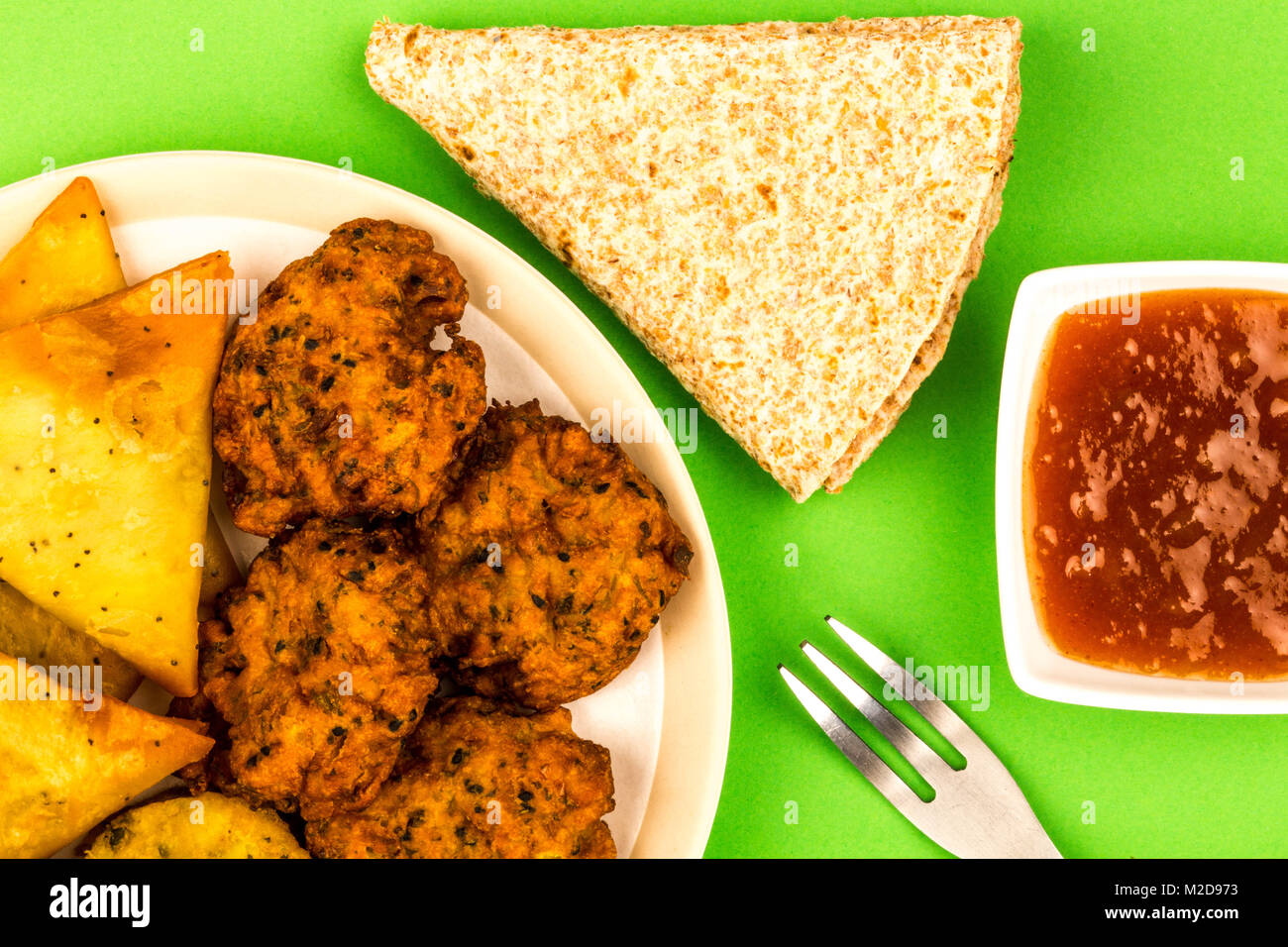 Indisches essen Snacks vegetarische Tikka vegetarische Samosa Zwiebel Bhaji mit chapatis Fladenbrot vor einem grünen Hintergrund Stockfoto
