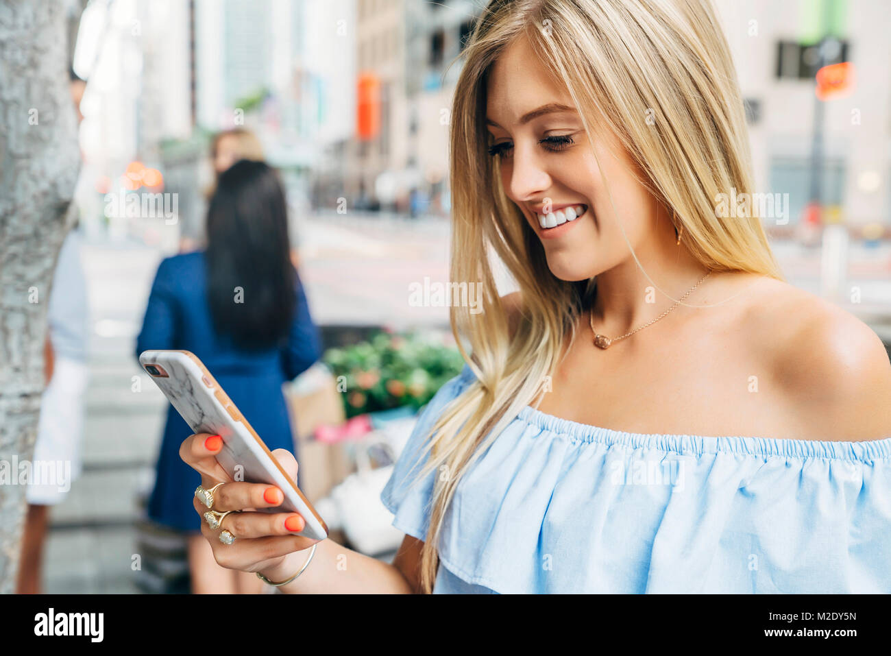 Nahaufnahme der kaukasischen Frau SMS auf Handy in der Stadt Stockfoto