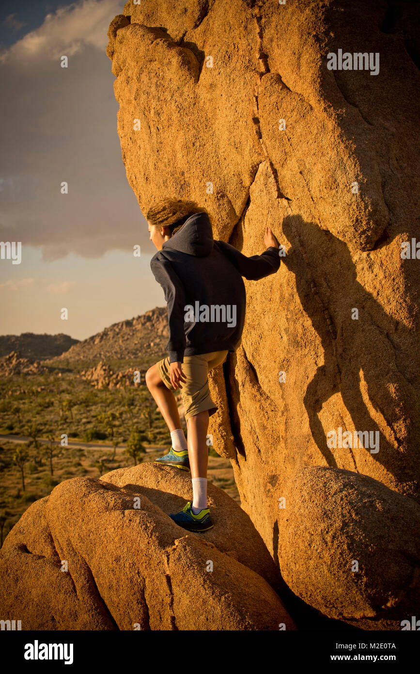 Gemischten rennen Junge stehend auf Felsen in der Wüste Stockfoto