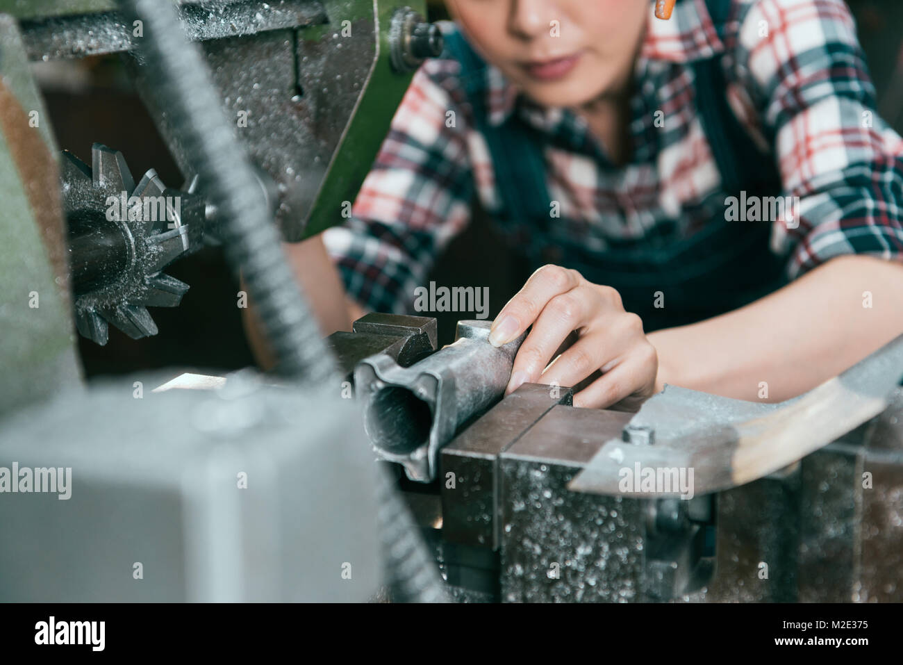Nahaufnahme der weiblichen Arbeitnehmer Fräsen von Stahl Komponenten in lathe Machine Factory. selektive Fokus Foto. Stockfoto