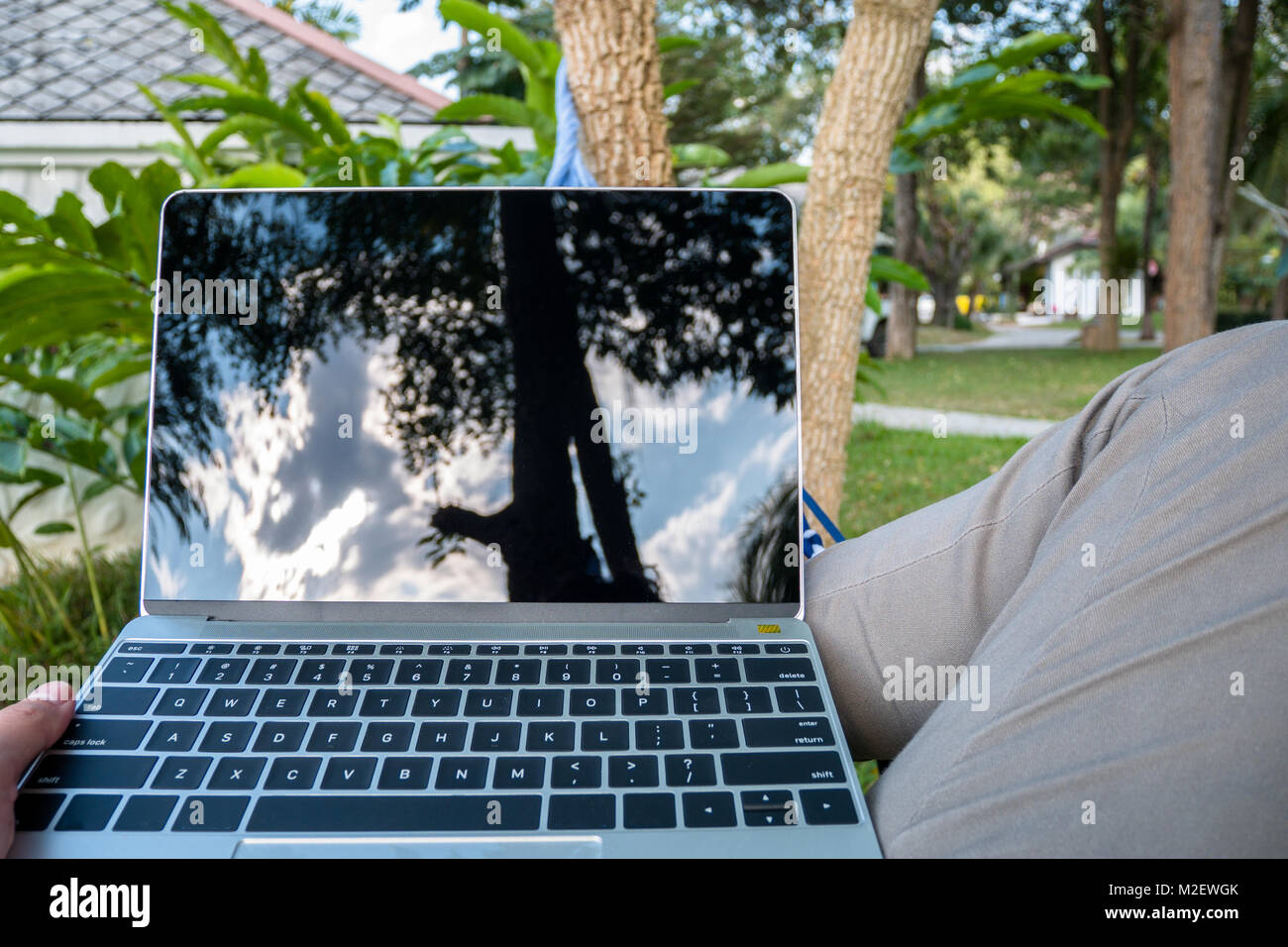 Nahaufnahme der Mann in einer Hängematte mit Laptop im Urlaub entspannen Zeit Stockfoto