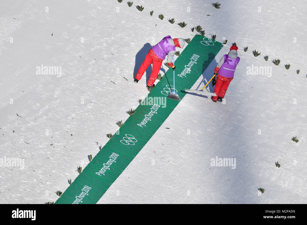 Allgemein, Helfer entfernen Schnee mit Besen im Schanzenauslauf, Skijjumping, Skispringen, Training am 08.02.2018, Olympische Winterspiele 2018, vom 09.02. - 25.02.2018 in PyeongChang/Suedkorea. | Verwendung weltweit Stockfoto