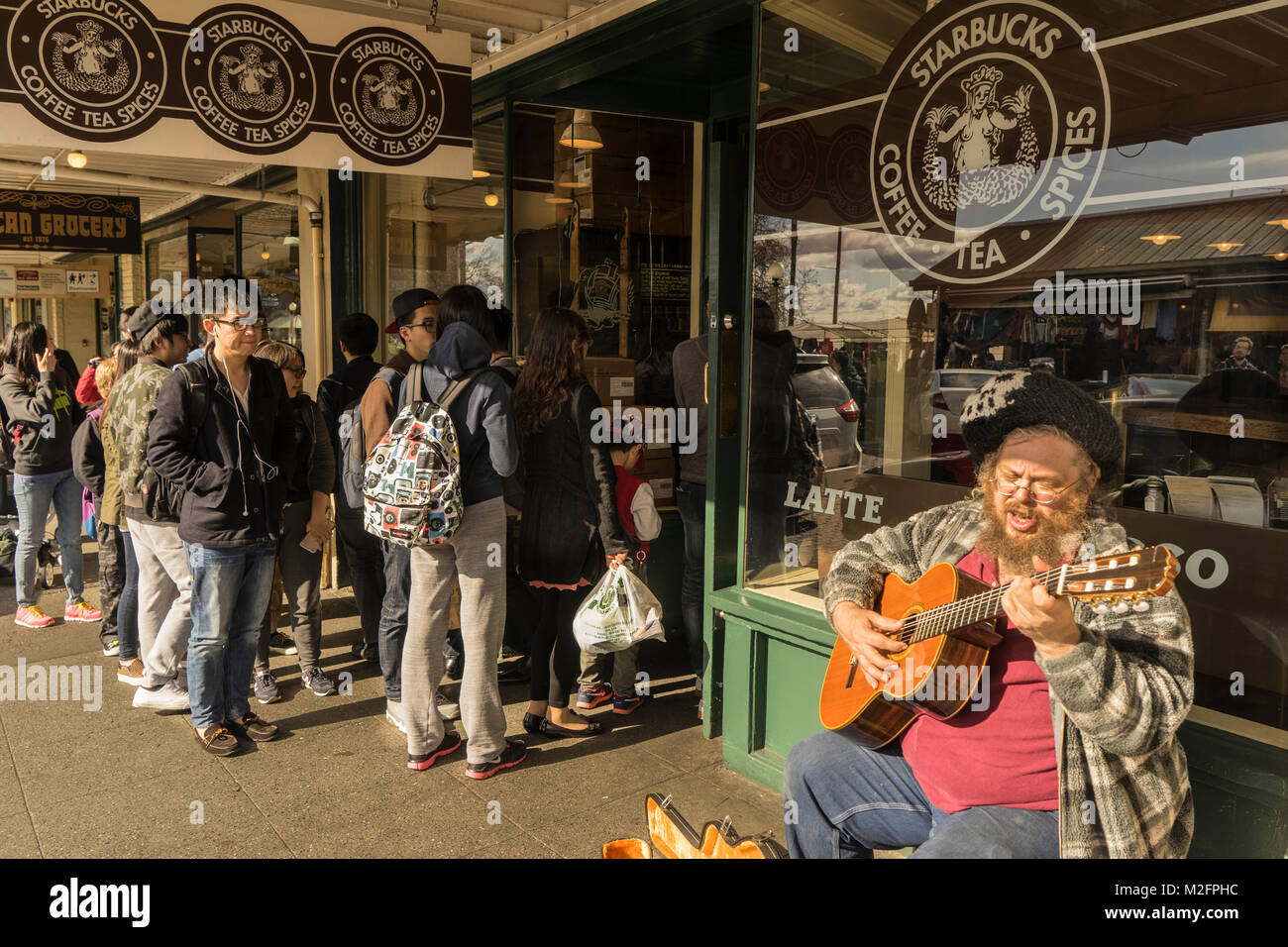 Usa, Washington, Seattle, ein Straßenmusikant spielen vor Kaffee von Starbucks in der Pike Place Market Stockfoto