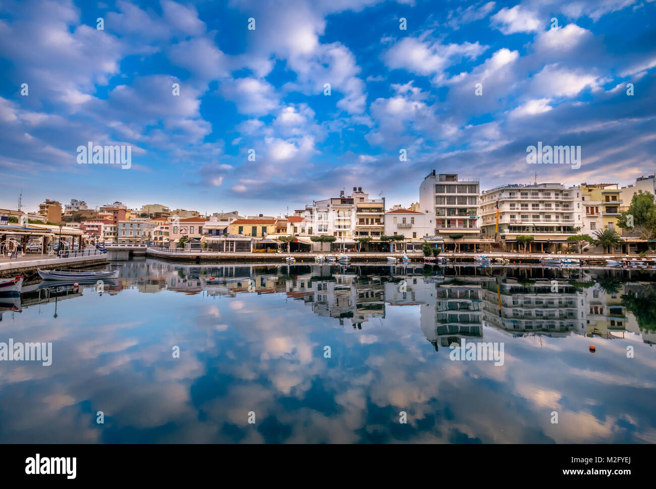 Agios Nikolaos, Kreta - 31. Januar 2018. Tolle Aussicht mit Reflexionen an Voulismeni See. Dramatische Himmel mit bunten Gebäude eines der größten Population Stockfoto