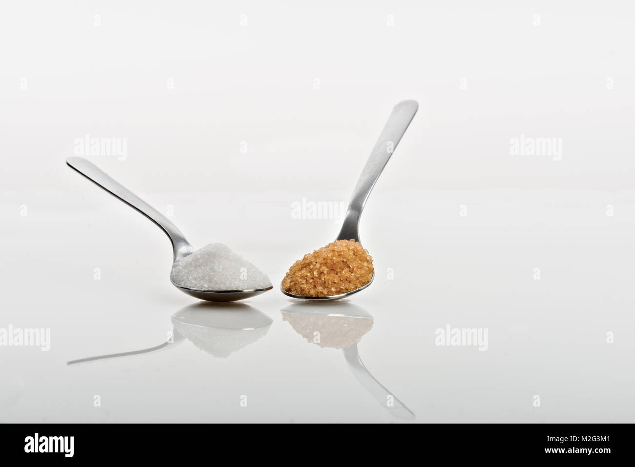 Löffel mit braunen und weißen Zucker von oben Stockfoto