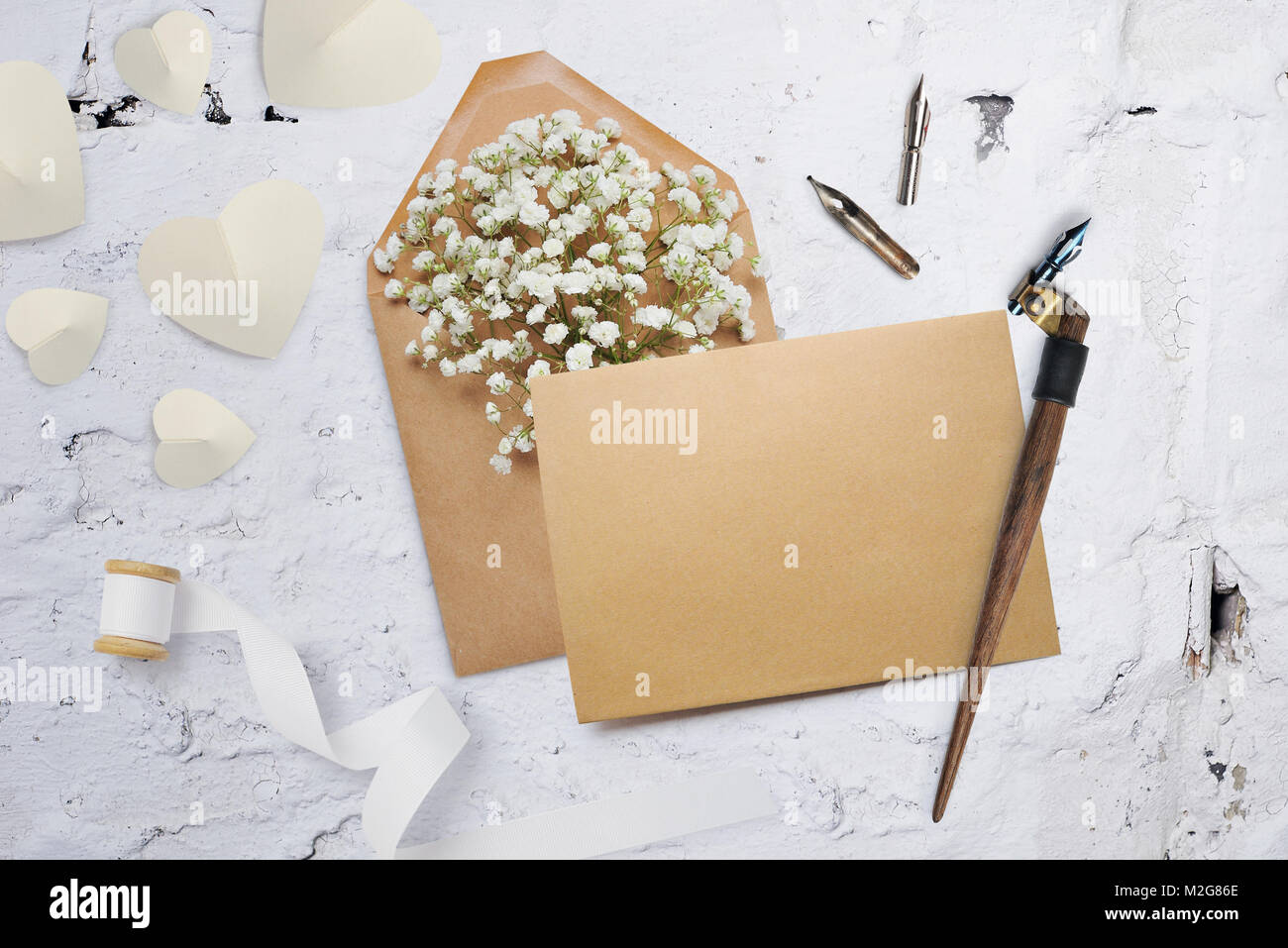 Kalligrafische Feder einen Umschlag mit Blumen und einem Brief, Grußkarte für Valentines Tag mit Platz für Ihren Text. Flach, Ansicht von oben Foto Mock up Stockfoto