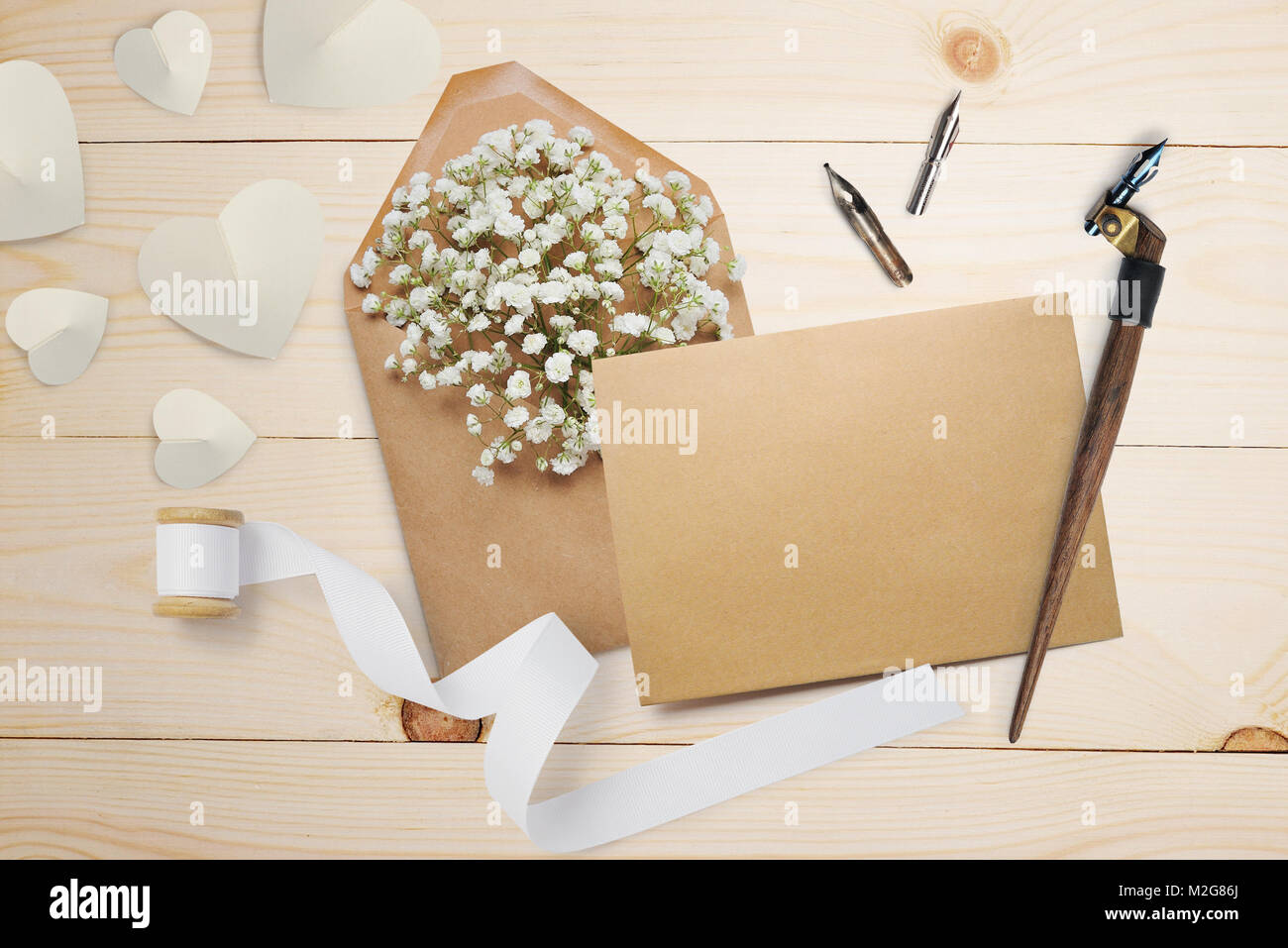 Kalligrafische Feder einen Umschlag mit Blumen und einem Brief, Grußkarte für Valentines Tag mit Platz für Ihren Text. Flach, Ansicht von oben Foto Mock up Stockfoto
