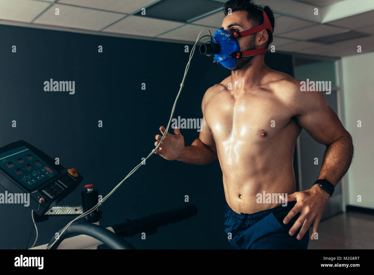 Fit und muskulöse Athleten mit Maske auf Laufband für seine Performance Monitoring. Sportler in Sport Science Lab seine Leistung messen. Stockfoto