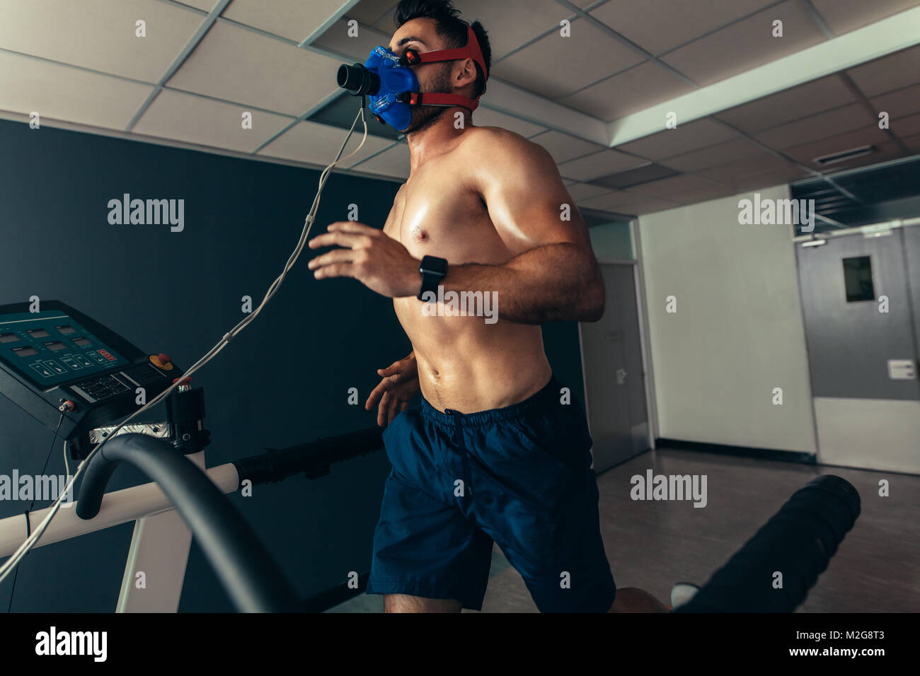 Athlet einen Performance Test im Sport lab. Läufer mit Maske auf Laufband Maschine und Prüfung der Leistung. Stockfoto