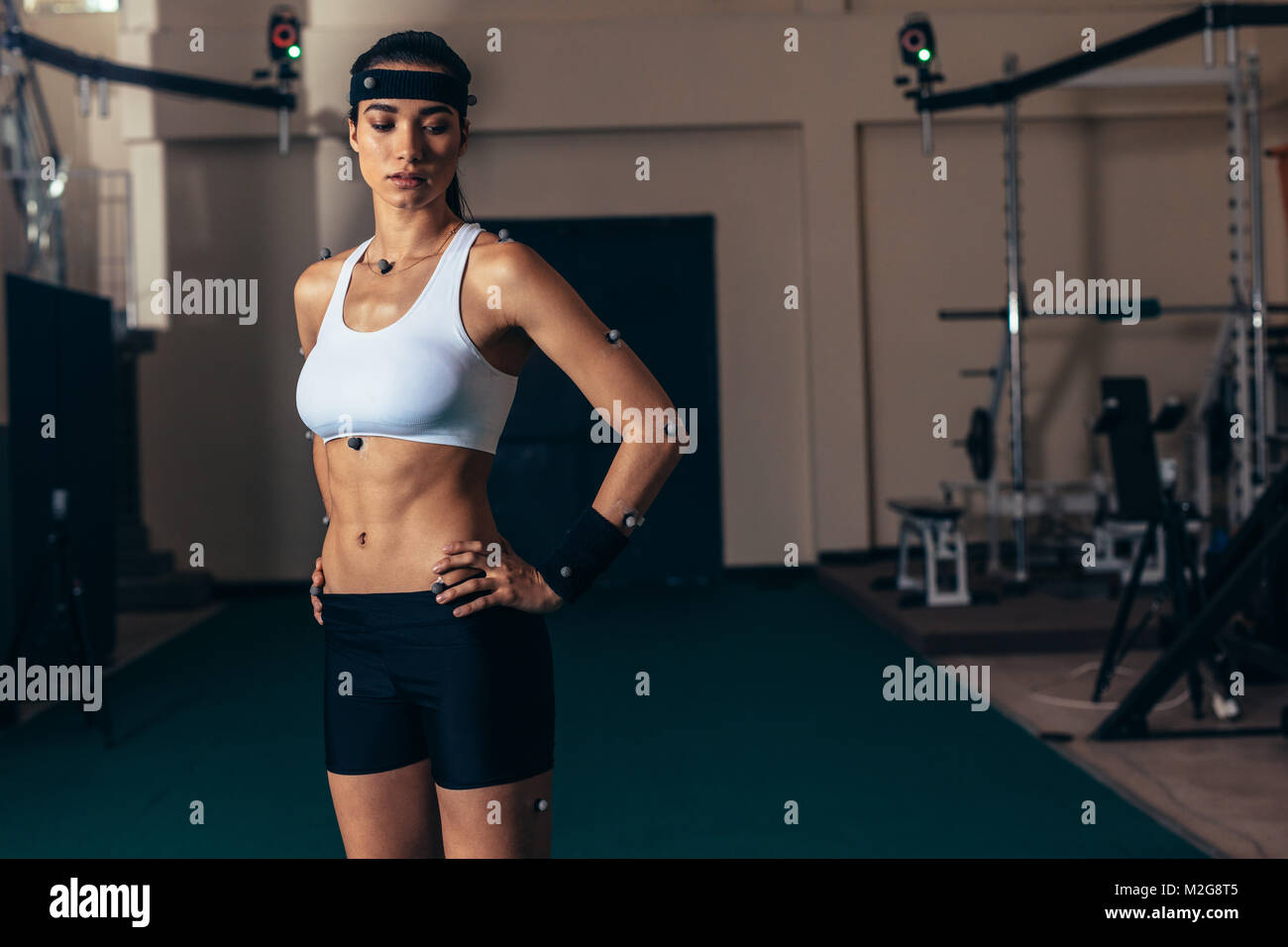 Weiblichen Athleten mit Motion Capturing Sensoren auf ihrem Körper die Bewegung und Leistung in der Biomechanik Labor aufzeichnen. Stockfoto