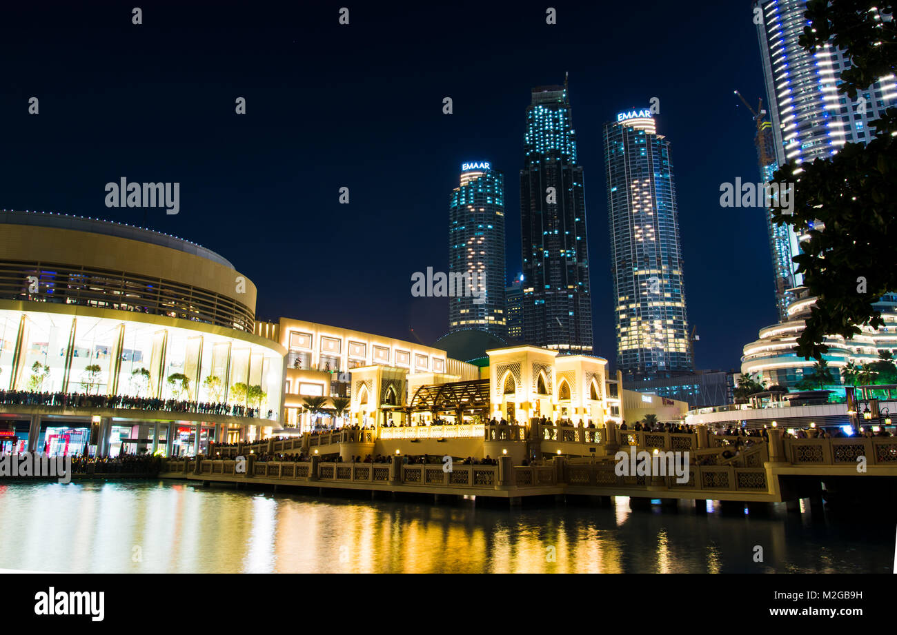 DUBAI, VEREINIGTE ARABISCHE EMIRATE - Februar 5, 2018: Dubai Mall Gebäude und benachbarten Wolkenkratzer in den Brunnen bei Nacht wider. Die Dubai Mall ist Stockfoto