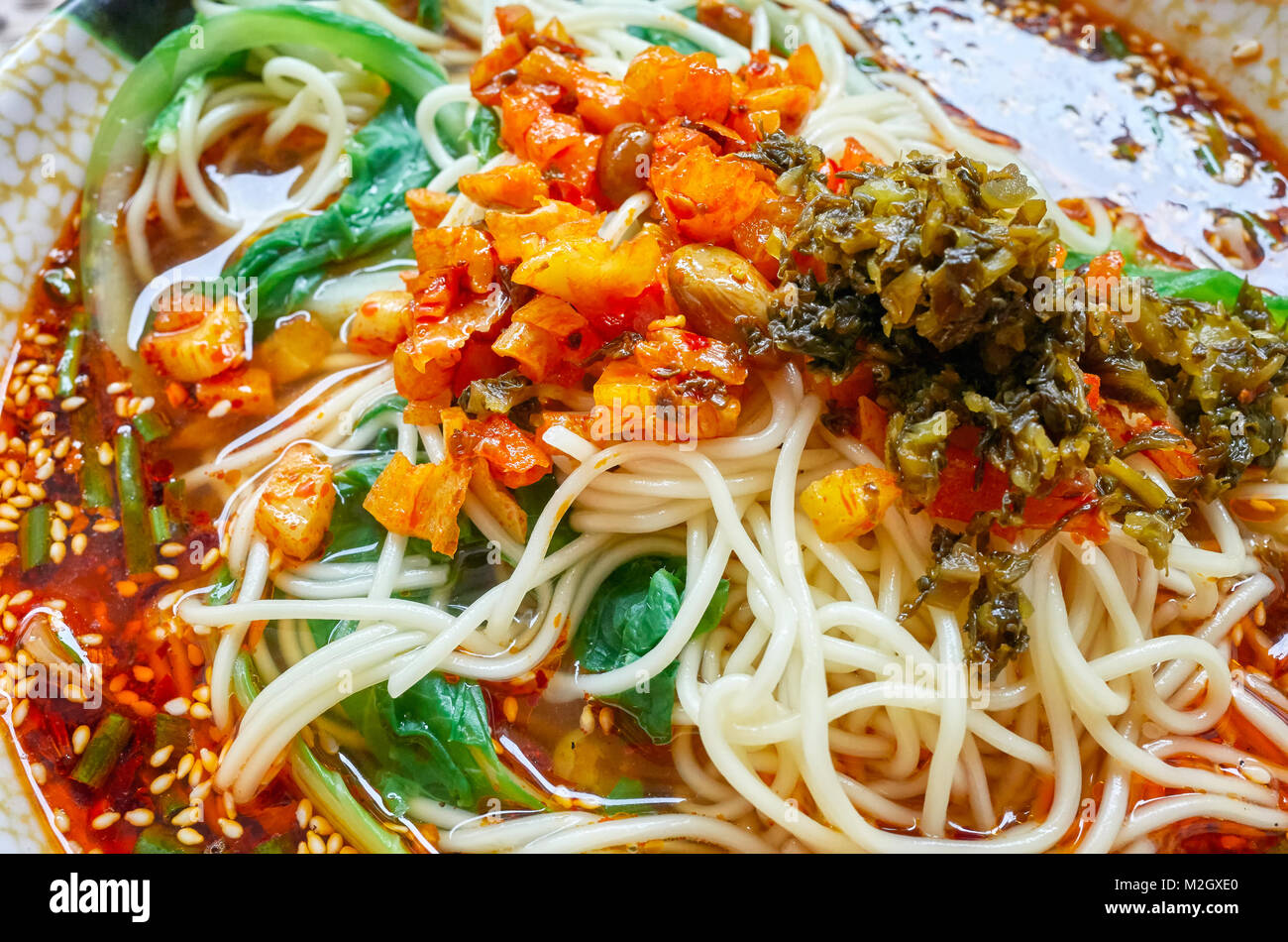 Würzige Nudelsuppe mit Gemüse, Kräutern, Erdnüssen und Koriander, beliebt in der Provinz Yunnan, geringe Tiefenschärfe, China. Stockfoto