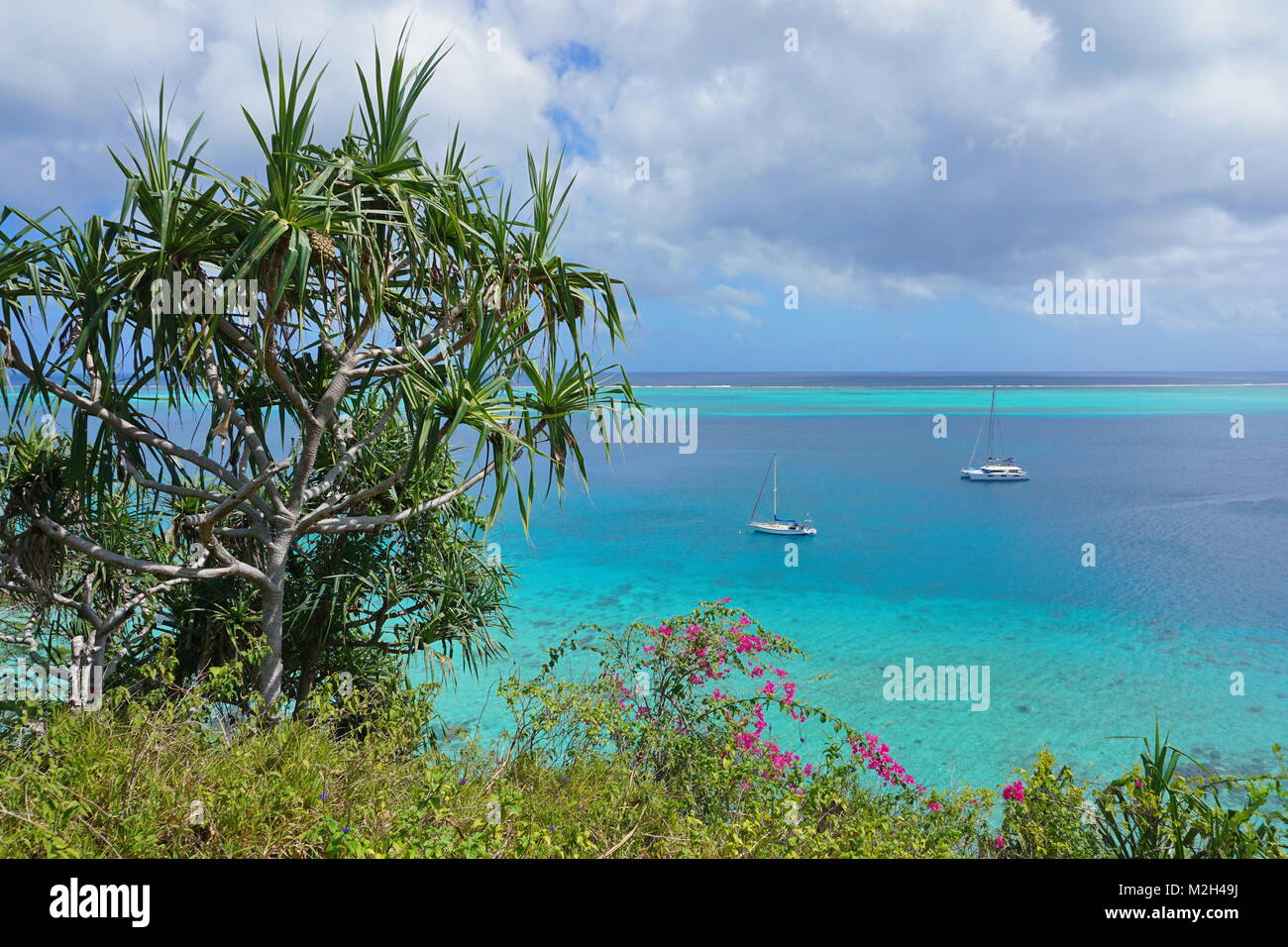 Grüne Vegetation und Segelboot blau Wasser von einer tropischen Lagune verankert, South Pacific Ocean, Huahine Island, Französisch Polynesien Stockfoto