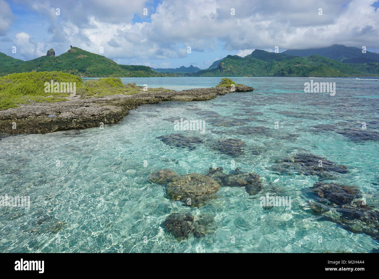 Die Lagune mit einer felsigen Insel auf der Insel Huahine in der Nähe von Maroe Bay, Pazifischer Ozean, Französisch Polynesien Stockfoto