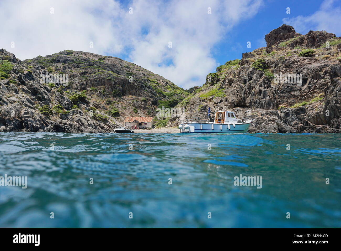 Felsige Küste mit Boot günstig in der Nähe einer Bucht mit einem Fischer Hütte, von der Meeresoberfläche gesehen, Mediterran, Cala Gentil, Spanien, Costa Brava, Cap de Creus Stockfoto