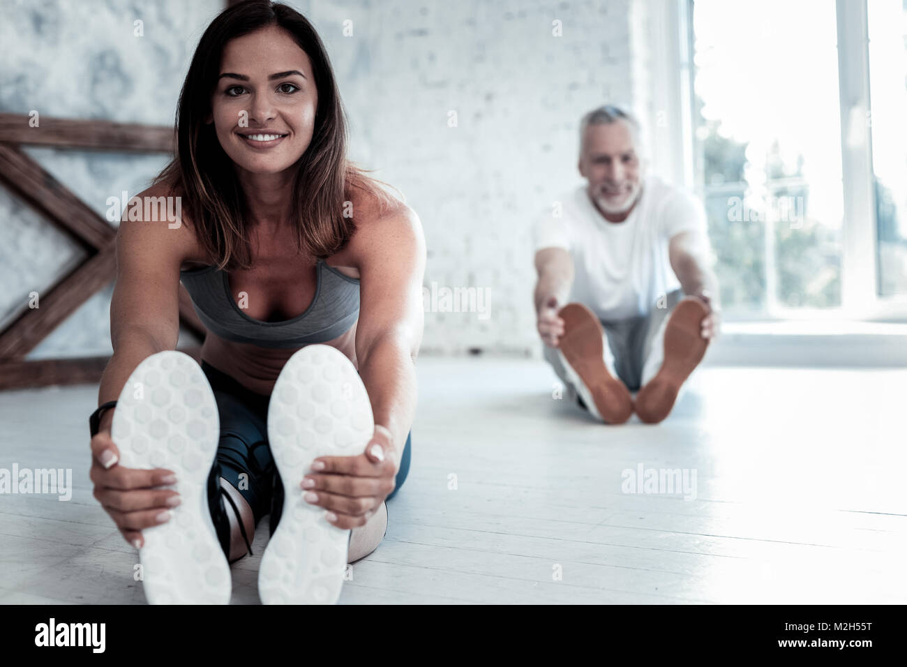 Fröhliche Menschen, die sich ihre Körper während Yoga Session Stockfoto