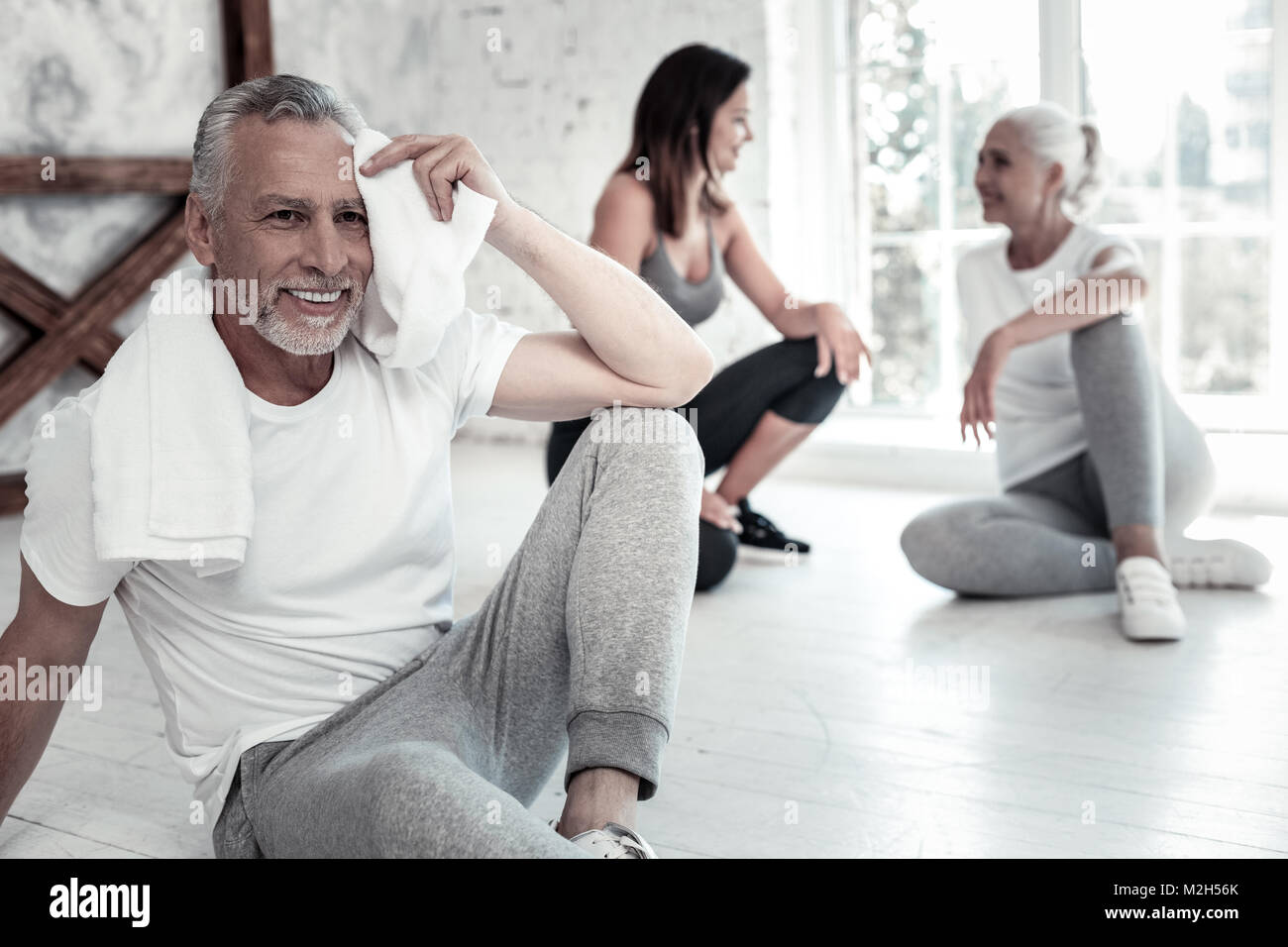 Fröhliche pensionierter Mann übertragen, während seine Stirn mit Tuch abwischen Stockfoto