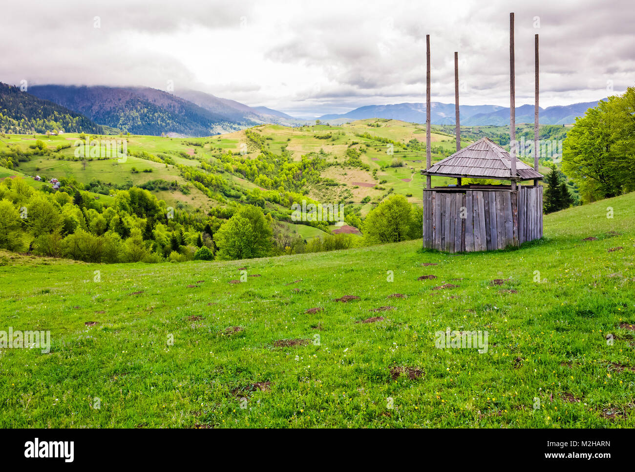 Alte hölzerne Heu Halle auf grasigen Hang. wunderschöne Landschaft des bergigen ländlichen Gegend im Frühling Stockfoto