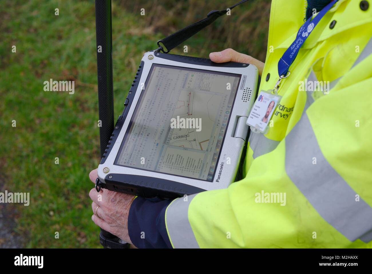 Ordnance Survey surveyor Plotten einer Entwicklung des neuen Gehäuses auf einer digitalen Karte mit GPS-Technologie, Wales, UK. Stockfoto