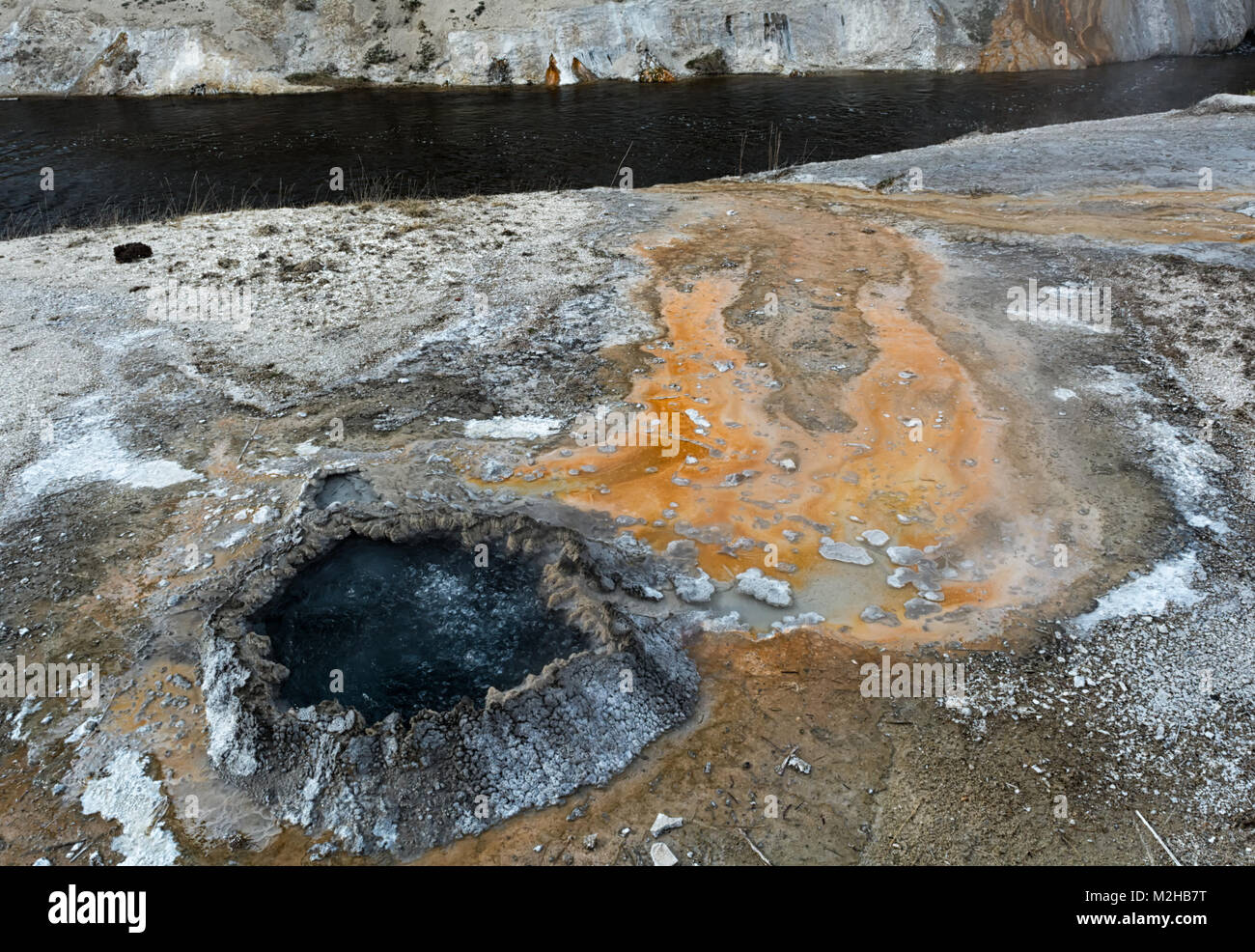 Eine sprudelnde Hotspring speist einen in der Nähe gelegenen Fluss mit überhitztem Wasser Geothermie angetrieben. Stockfoto